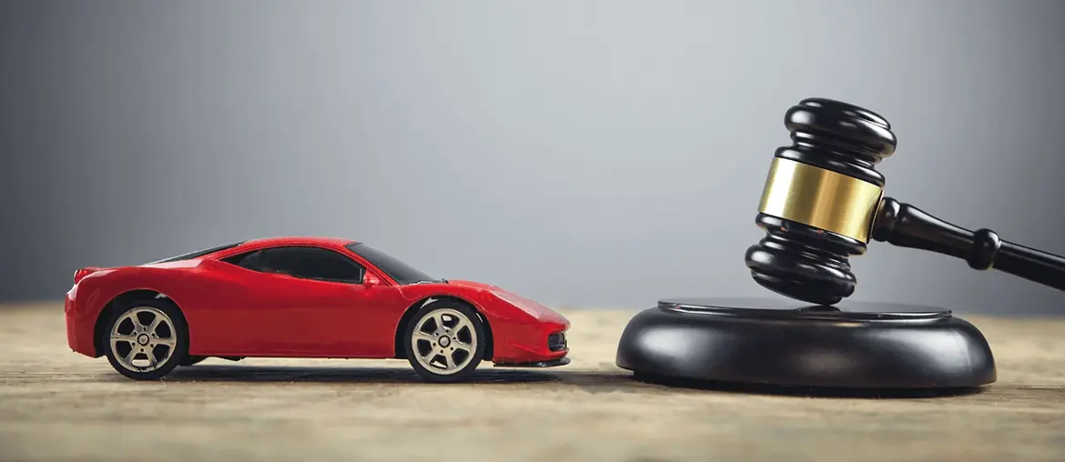 red car being displayed near the auction hammer